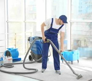 Ein Mitarbeiter nutzt ein professionelles Reinigungsgerät zur Tiefenreinigung eines Teppichbodens.